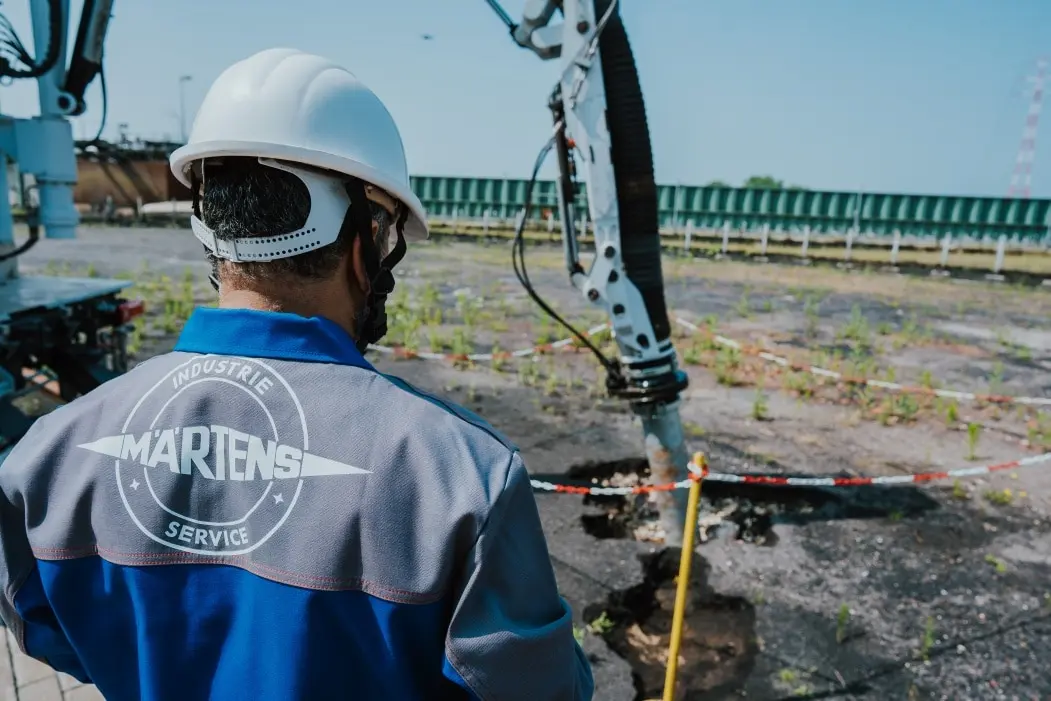 Industriearbeiter auf Baustelle mit schwerem Gerät im Einsatz